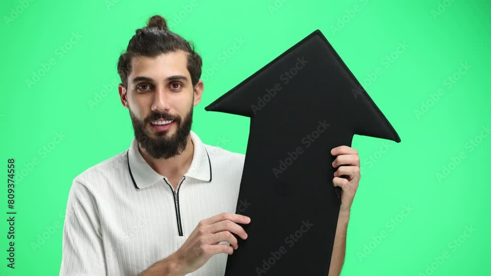 Man, close-up, on a green background, pointing up arrow Man, close-up, on a green background, pointing up arrow