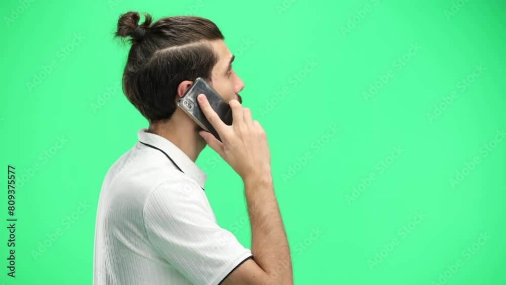Man, close-up, on a green background, with a phone Man, close-up, on a green background, with a phone