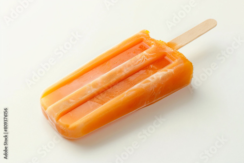a popsicle with orange and white toppings on a white surface