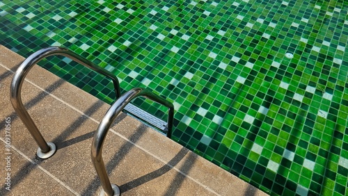 Swimming pool with green tile floor, green mosaic pool with handrail,