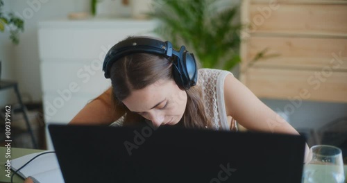 Modern Businesswoman Working Laptop Home Office Headphones Writing Notebook photo
