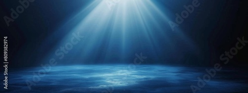 Dark blue background with light rays, glowing and shining on the floor, creating an atmospheric effect.