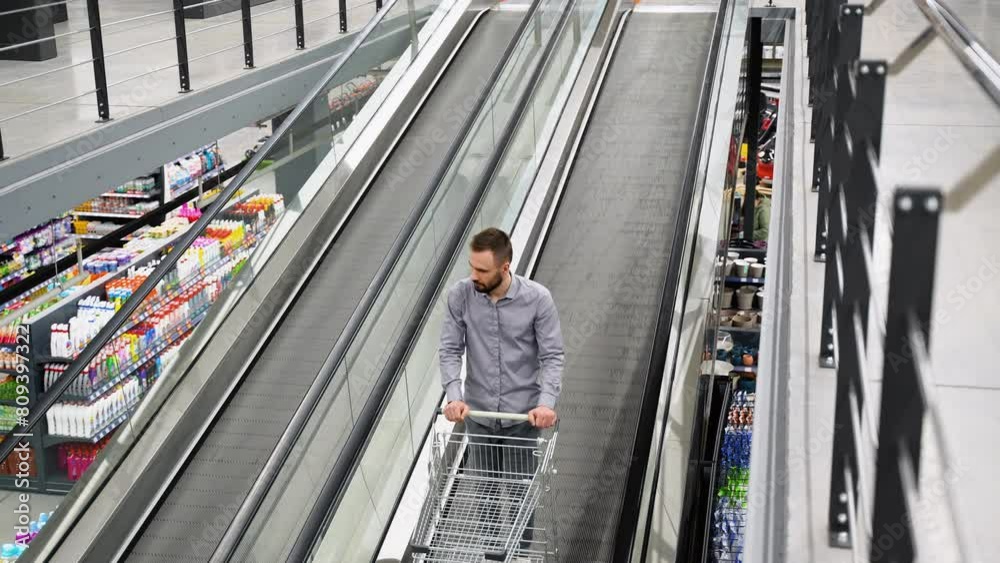 A man with a trolley on escalator in a hardware store A man with a trolley on escalator in a hardware store