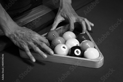 Male Hands setting balls for nine balls pool, black and white photo photo