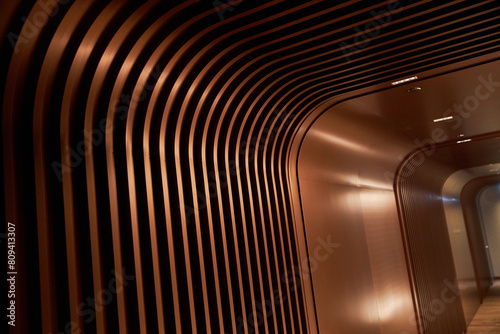 Curved metallic corridor bathed in warm light