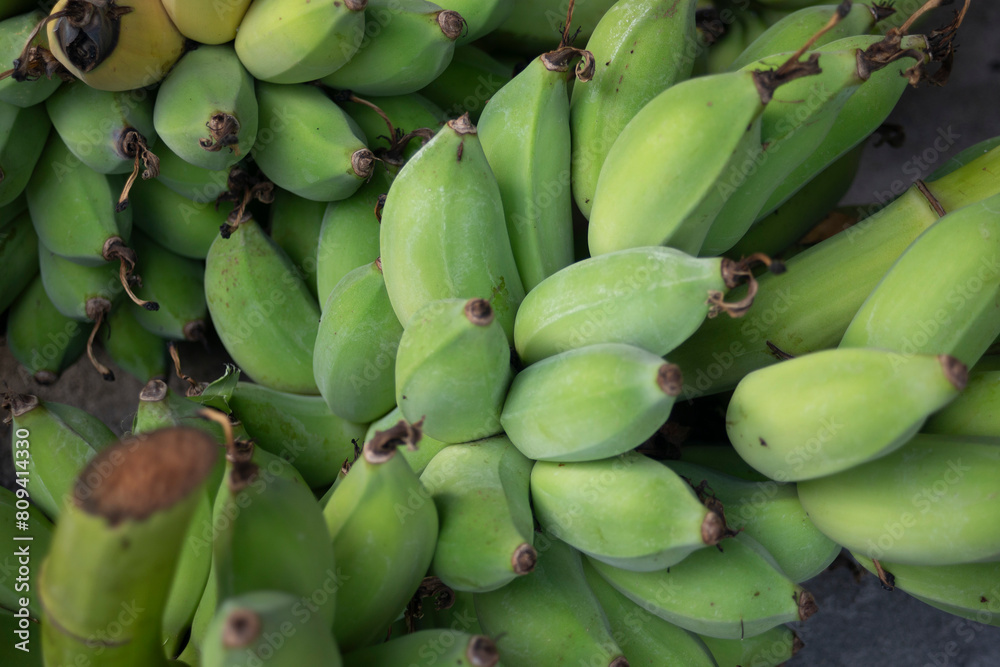 Bunch of ripe green bananas on the market. Selective focus. Bunch of ripe green bananas on the market. Selective focus.