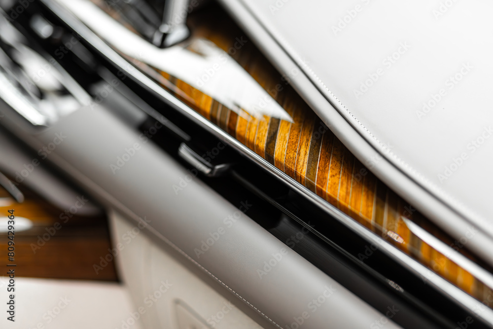 Close-up of a luxury car panel made of natural wood and leather Close-up of a luxury car panel made of natural wood and leather