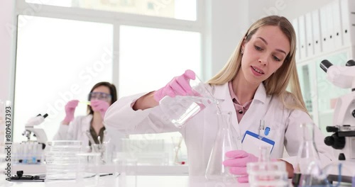 Women chemists in uniform work in modern laboratory photo