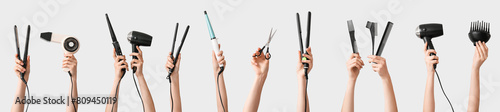 Many hands with hairdresser's supplies on grey background photo