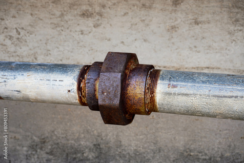 Rusty old metal pipe with valve and bolt
