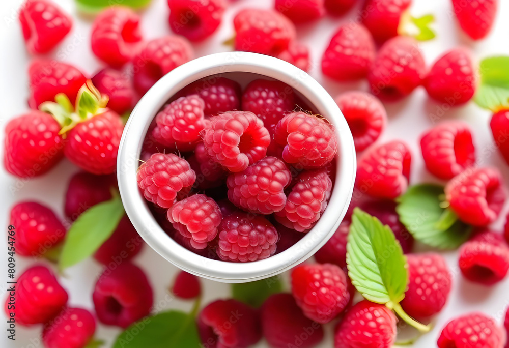 A close-up of red raspberries in a white cup on a white table A close-up of red raspberries in a white cup on a white table