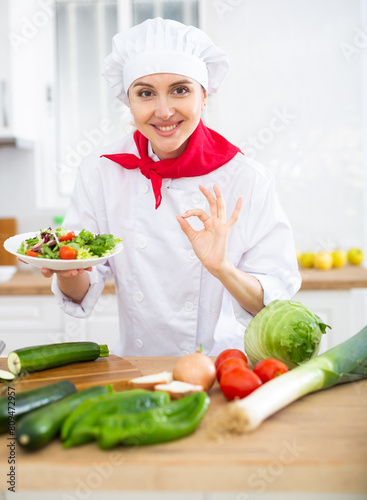 Female chef demonstrating excellent salad in the kitchen