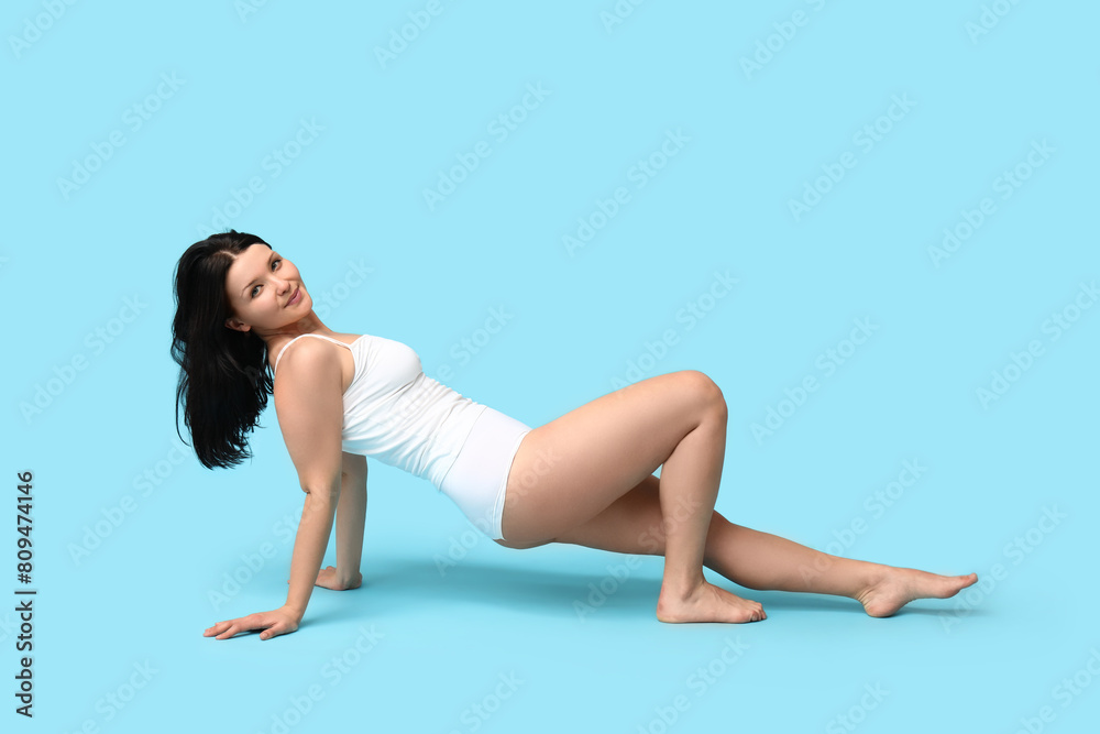 Body positive woman in underwear posing on blue background Body positive woman in underwear posing on blue background