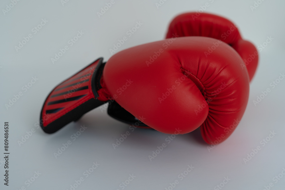 A red boxing glove with a black strap