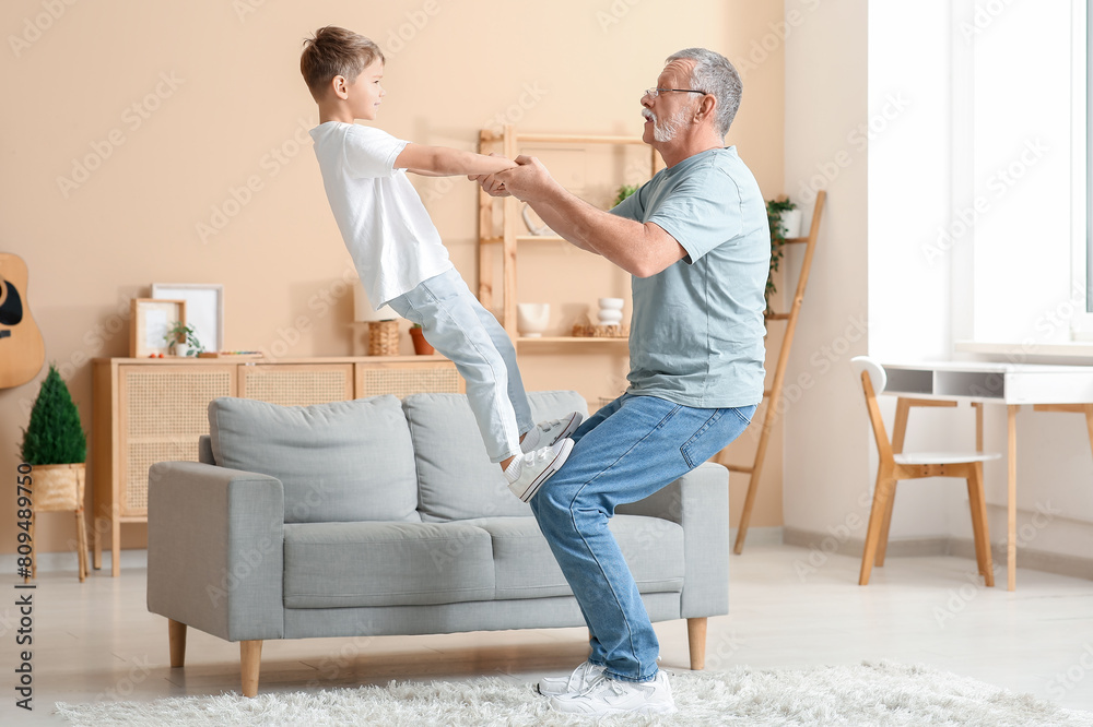 Grandfather with his cute little grandson having fun together at home Grandfather with his cute little grandson having fun together at home