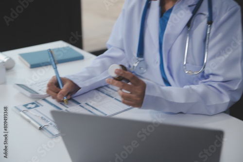 Cropped view of doctor in white coat holding bottle medication, prescribing pills to sick patient via online consultation. Family therapist recommend quality medicines. Healthcare, treatment concept