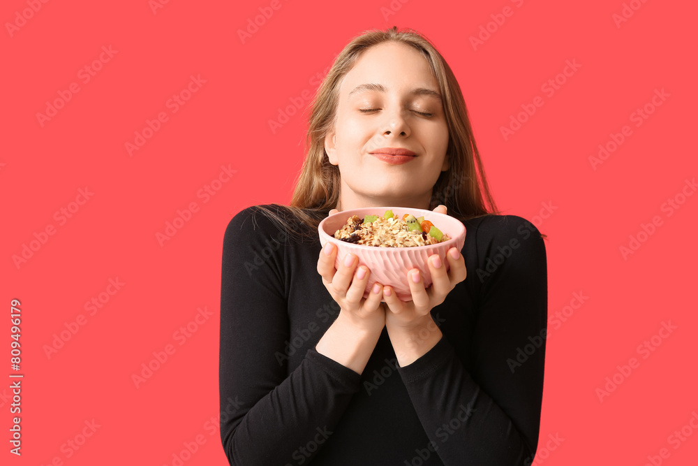 Young woman with bowl of healthy oatmeal on red background Young woman with bowl of healthy oatmeal on red background