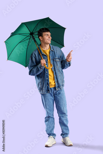 Young man with green umbrel...