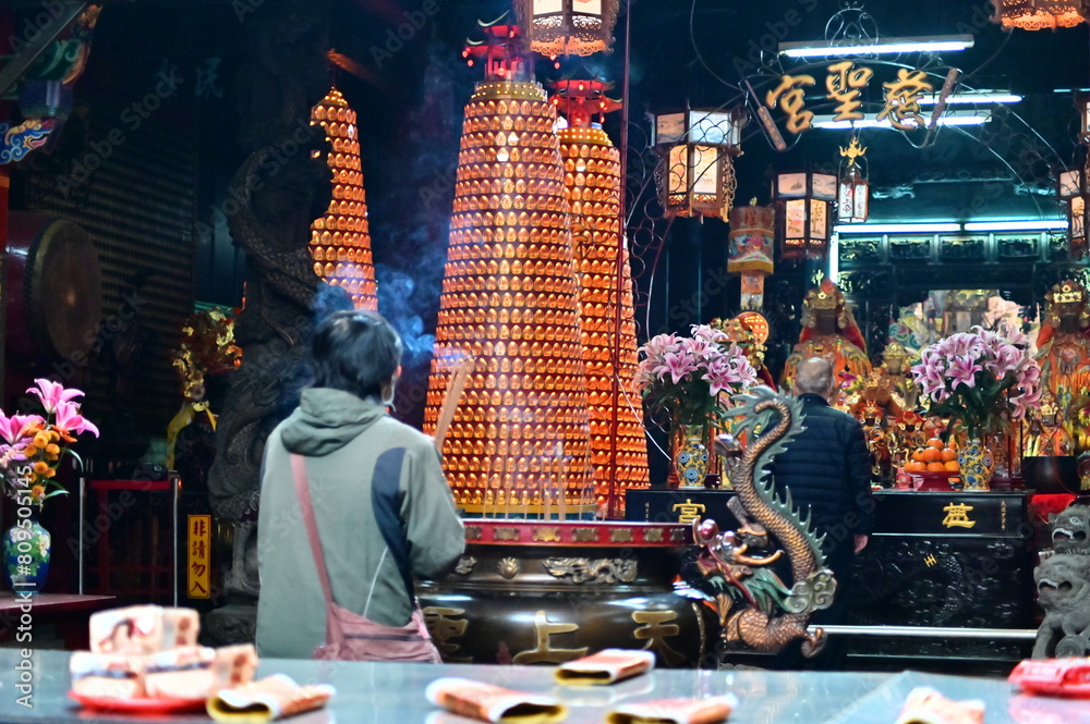 Taiwan - Feb 01, 2024: Devotees holding incense sticks and praying at Cisheng Temple (慈聖宮). In Taiwanese religious beliefs, incense bridges people and deities, symbolizing reverence and prayers.