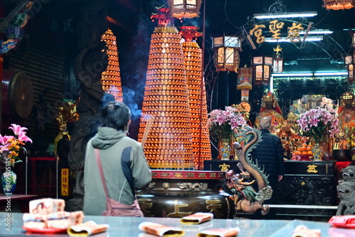 Obraz na płótnie Taiwan - Feb 01, 2024: Devotees holding incense sticks and praying at Cisheng Temple (慈聖宮). In Taiwanese religious beliefs, incense bridges people and deities, symbolizing reverence and prayers. w salonie