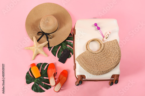 Composition with suitcase  beach accessories  mobile phone and sex toys on pink background