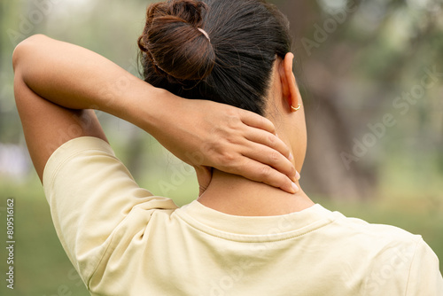 Women have neck pain, shoulder pain, at the park health concept.	