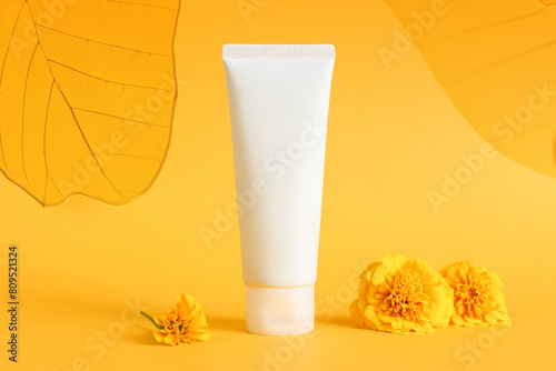 cosmetic moisturizer cream bottle tube, transparent leaves on yellow background. Shampoo, skincare, herbal facial cream, gel, sunblock sunscreen, sun skin protection. blank tube template mockup