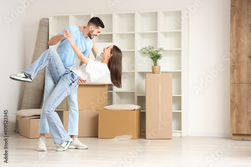 Happy young couple dancing in room on moving day