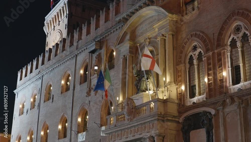 Bologna, Italy and EU flags waving on facade od Palazzo d Accursio at night with Statue of Pope Gregory XIII disguised as Saint Petronius photo