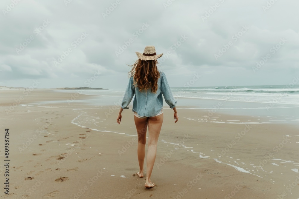 young woman walks on beach alone back view copy space