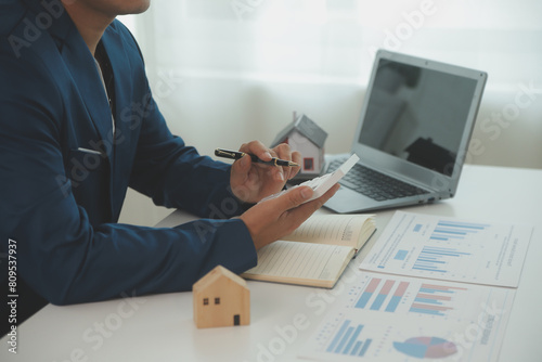 Fotografie Businessmen holding pens, signing home titles with insurance, care about real estate services and the idea of real estate agents offering interest in installments to their customers