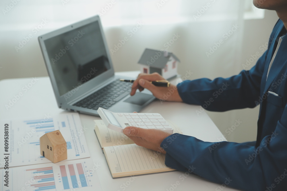 Businessmen holding pens, signing home titles with insurance, care about real estate services and the idea of real estate agents offering interest in installments to their customers.