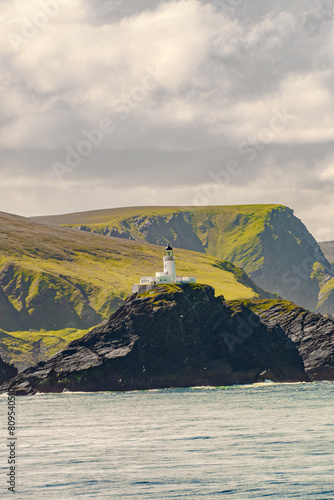 Muckle Flugga lighthouse Shetland, Scotland. Cover page with gorgeous sunset over fjords landscape and seascape.