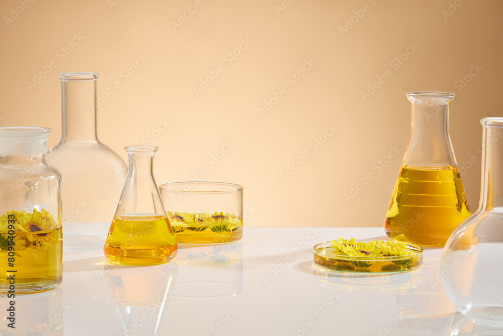 Light brown background against some lab equipments neatly arranged on white table with pure calendula extract inside. Blank space for adding text and elements of design Light brown background against some lab equipments neatly arranged on white table with pure calendula extract inside. Blank space for adding text and elements of design