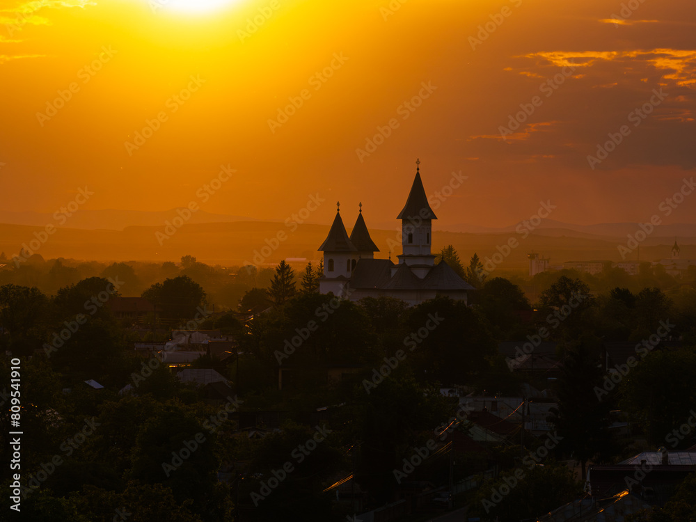 Orthodox church in sunset light. Amazing aerial view during sunset over a landmark orthodox church in Moldova region from Romania. Church and Christian cross silhouette religion.