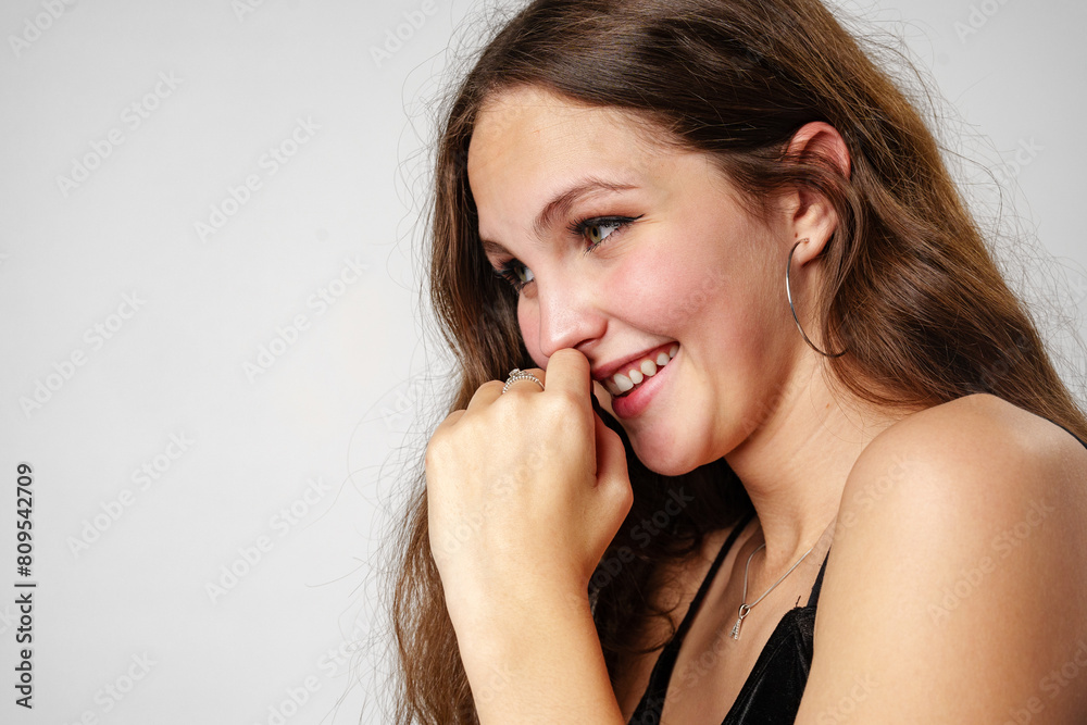 Smiling Young Woman Posing in a Black Top Against a Grey Background Smiling Young Woman Posing in a Black Top Against a Grey Background
