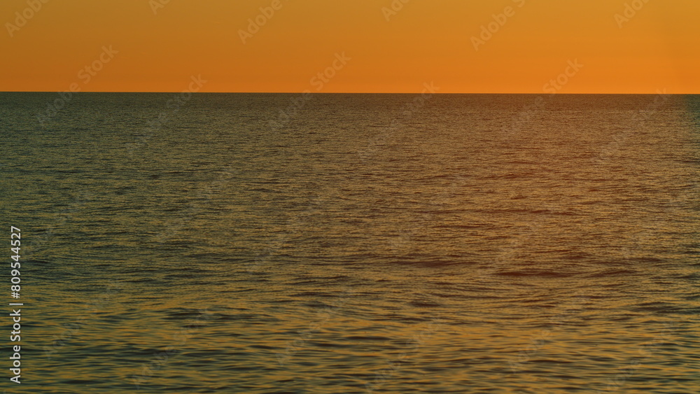 Beautiful Sunset Above Sea. Sunrays Flickering In Ripples On Water Surface. Natural Sky Reflects In Sea Warm Colors. Slow motion.