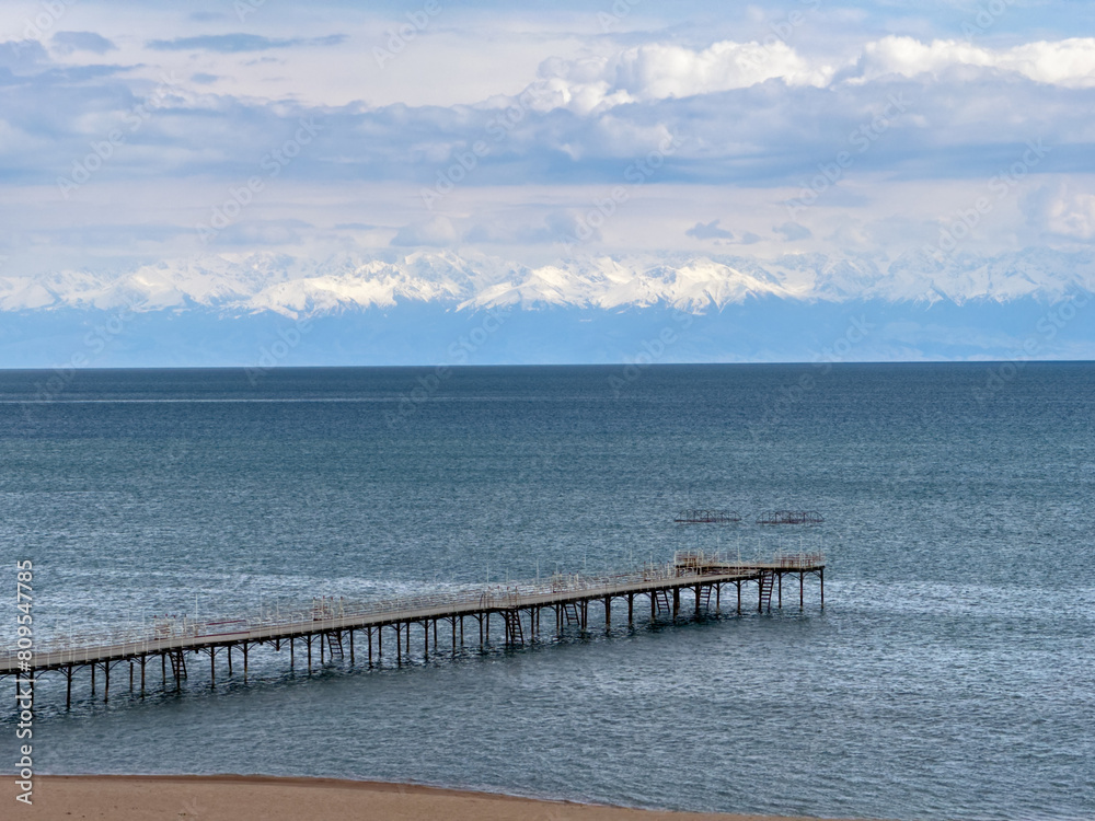 Sunny summer day on the lake. Mountains and sea. Kyrgyzstan, Lake Issyk-Kul Sunny summer day on the lake. Mountains and sea. Kyrgyzstan, Lake Issyk-Kul