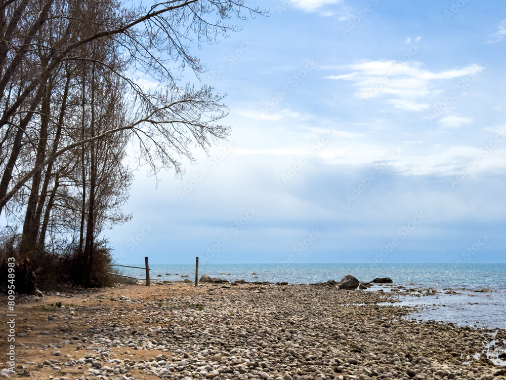 Sunny summer day on the lake. Mountains and sea. Kyrgyzstan, Lake Issyk-Kul Sunny summer day on the lake. Mountains and sea. Kyrgyzstan, Lake Issyk-Kul