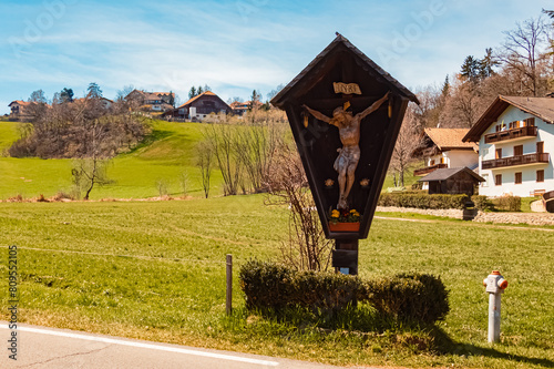 Alpine spring view with a religious cross near Klobenstein, Ritten, Eisacktal valley, South Tyrol, Italy