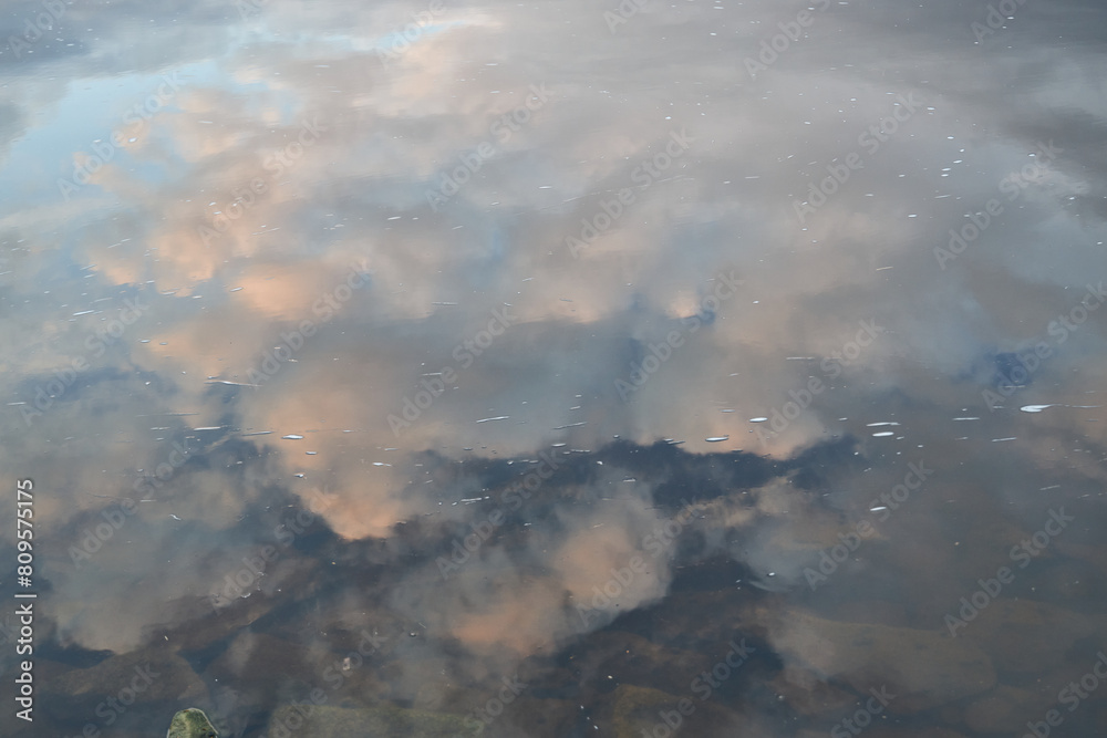 clouds reflect in the river in summer