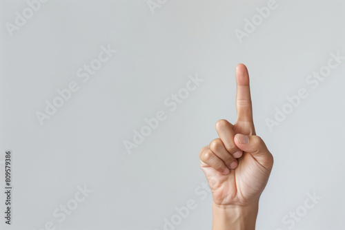Hand showing raised index finger on plain copy space