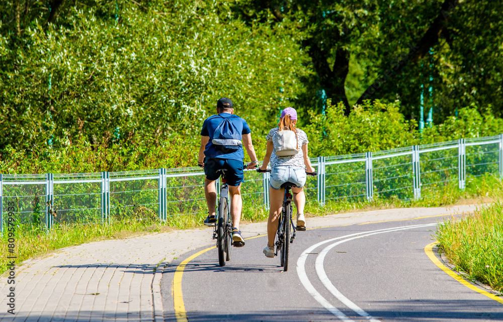 Obraz premium Cyclists ride on the bike path in the city Park