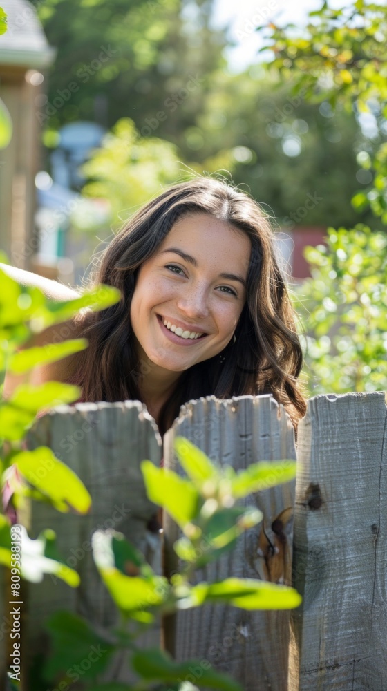 Beautiful young woman looks out from behind fence. Beautiful young woman looks out from behind fence.