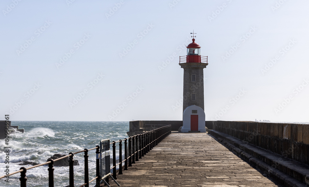 Lighthouse on a Porto city Portugal beach with dramatic waves of atlantic ocean