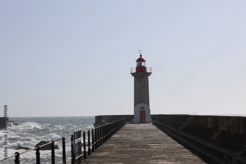 Lighthouse on a Porto city Portugal beach with dramatic waves of atlantic ocean