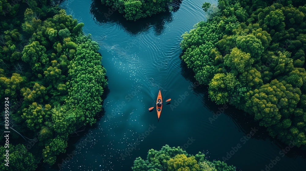 Aerial view of a kayaker paddling on a scenic river with beautiful landscape