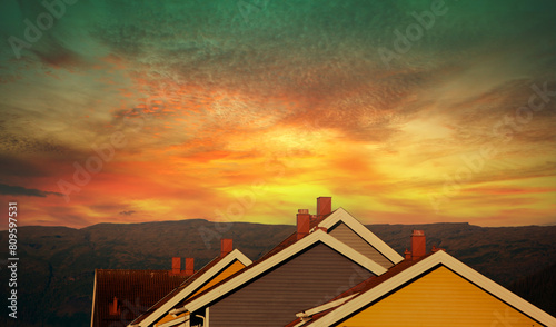 Silhouette of the roofs of wooden houses against a beautiful dramatic sunset sky. Typical architecture of Scandinavian countries. Row of wooden houses. Norway photo