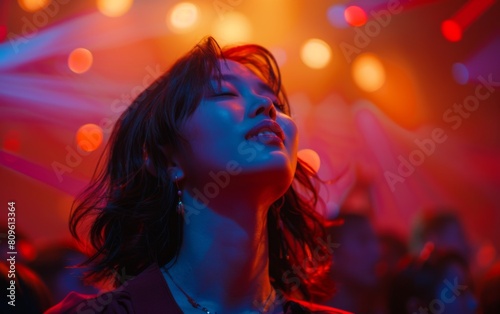 A woman is smiling at the camera in a club. The lights are bright and colorful, creating a fun and energetic atmosphere