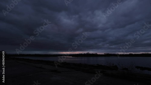 breve e rapido timelapse con visuale panoramica su di un ambiente naturale nei pressi di un fiume, nel nord est Italia, dopo il tramonto, sotto un cielo variabile completamente nuvoloso photo